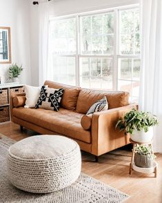 a living room filled with furniture and large windows