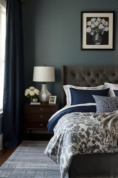 a bed with blue and white comforter in a bedroom next to a window on a rug