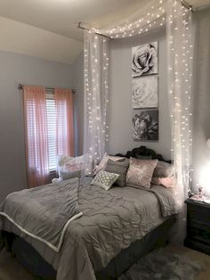 a bed with white sheets and lights hanging from it's headboard in a bedroom