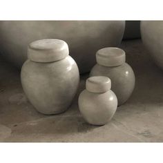 three white vases sitting next to each other