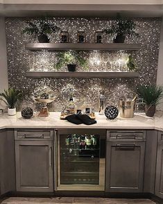 a kitchen with stainless steel cabinets and white marble counter tops is decorated with potted plants