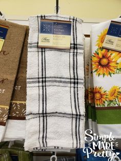 towels are hanging on a rack in a store with sunflowers and other items