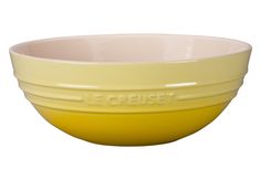 a yellow bowl with the word le creuset written on it in white lettering