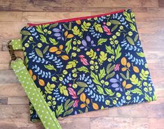 a blue and green floral print zippered pouch with a polka dot ribbon on the side