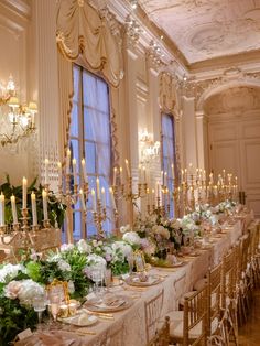 a long table is set with flowers, candles and place settings for an elegant dinner