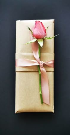 a wrapped gift with a single rose on it