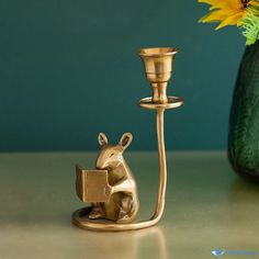 a brass colored candle holder with a small animal figurine next to it