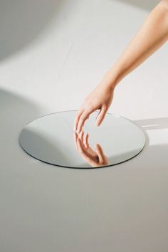 a person reaching for something in the center of a circular object with their hand on it