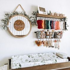 a baby crib with several items hanging on the wall