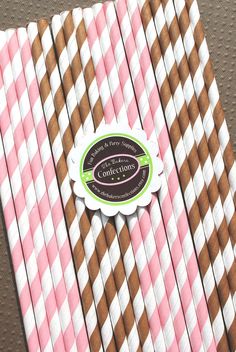 pink and brown striped paper straws are stacked on top of each other in rows