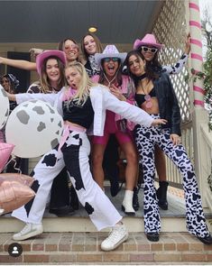 a group of women in costume posing for a photo on the front steps of a house