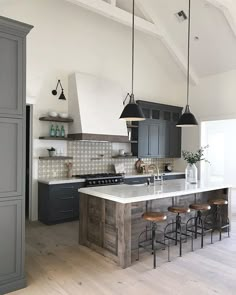 a large kitchen with an island and bar stools