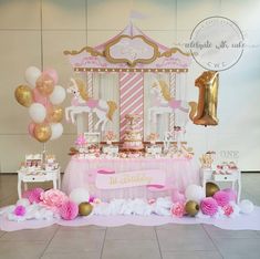 a pink and gold carousel birthday party with balloons, streamers, tablecloths and decorations