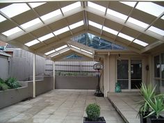 an outdoor patio with a skylight and potted plants