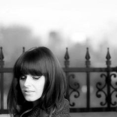 black and white photograph of a woman sitting on a bench looking at her cell phone