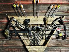 an image of a bow and arrows in the shape of a triangle on wooden planks