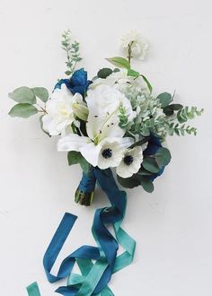 a bouquet of white and blue flowers with green ribbons on the bottom left hand side