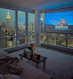 a living room filled with furniture and a big screen tv mounted to the side of a wall