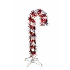 a candy cane decorated with red and white tinsels on a tripod stand