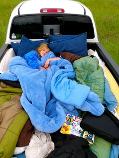 a black and white photo of a child sleeping in the back of a truck