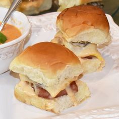 two sliders on a plate with a bowl of soup in the middle and another sandwich to the side