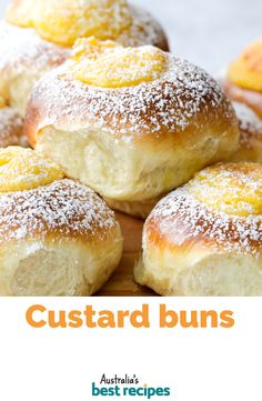 some sugar covered buns on a cutting board with the words custard buns above them