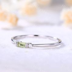 a close up view of a ring on a white surface with flowers in the background