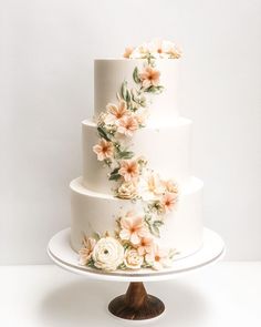 a three tiered white cake with flowers on it