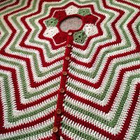 a red and green crocheted blanket with a button on it