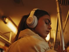 a woman wearing headphones while sitting on a bus