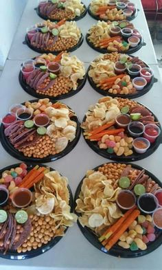 a table topped with black plates filled with food