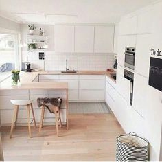 a kitchen with white cabinets and wooden floors