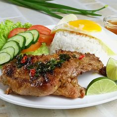 a white plate topped with meat, rice and veggies