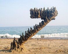 a tree made out of rocks sitting on top of a sandy beach