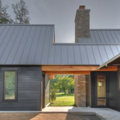 a house with a metal roof and stone pillars