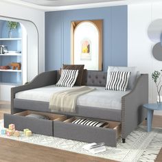 a day bed with storage drawers in a blue and white living room, next to a coffee table