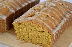 two slices of pumpkin bread with icing on a cutting board next to each other