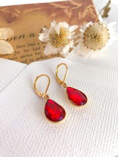 MYTHIC FLAME  *This item includes a short FAIRY TALE with the name of your choice.  Please leave a NOTE TO SELLER what NAME you want to appear in the story.  If you do not leave a message to the seller, the fairy tale will appear with the main name we chose.  Experience the Magic: Elevate your style with our golden stainless steel earrings featuring mesmerizing red crystal teardrops. Each pair comes with a personalized fairytale, allowing you to immerse yourself in a world of magic. Unleash Your Bachelorette Accessories, Bridesmaid Bachelorette, Hot Jewelry, Red Jewelry, Steel Earrings, White Jewelry, Red Crystals, Stainless Steel Earrings, Love Symbols