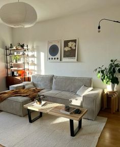 a living room filled with furniture and a wooden table on top of a hard wood floor