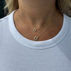 The 14K Gold Star Of David Necklace, also known as the Shield of David or Magen David in Hebrew, represents protection, providence, and good luck. Add a Hebrew nameplate and proudly showcase your faith. Available in 3 sizes for the perfect fit. Item Information Metal: 14k Gold Weight: Small - 1.80g Medium - 2.20g Large - 2.70g Chain Length: 16"+1"+1" Dimensions: Small - 9mm Medium - 12mm Large - 18mm Star Of David Necklace, Jewelry Accessories Ideas, The Shield, Star Of David, Gold Star, Rose Gold Necklace, Gold Stars, Name Plate, Chain Lengths