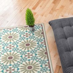 a potted plant sitting on top of a rug next to a chair and ottoman