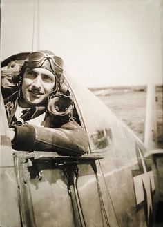 a black and white photo of a man in an airplane with pilot's goggles