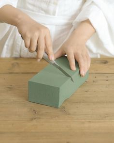 a child is cutting into a green block with a knife