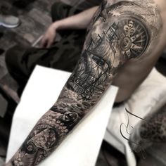 a man with a tattoo on his arm is sitting in front of a clock and octopus