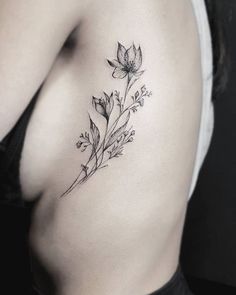 a woman's stomach with a flower tattoo on it