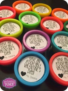 there are many different colored cups with sayings on them in the shape of hearts