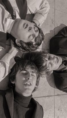 three young men laying on the ground looking up