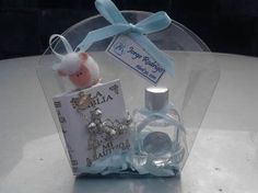 a small glass bottle with a tiny doll in it sitting on a table next to a card