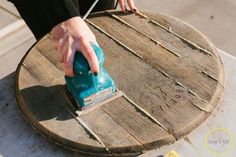 a person using a sander on top of a wooden table