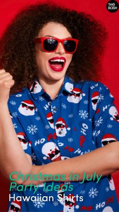 a woman wearing red sunglasses and a blue shirt with santa clause on it, holding her fist up